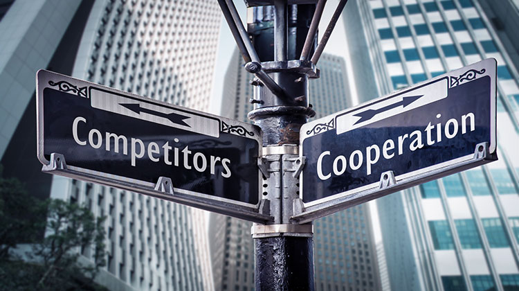 Zwei Strassenschilder mit der Aufschrift Competitors und Cooperation