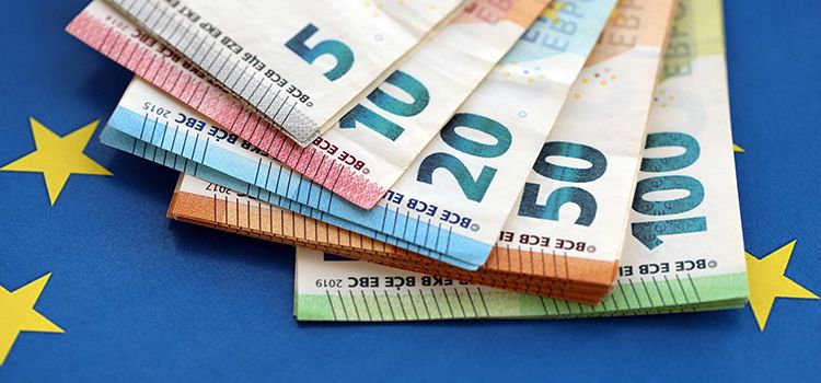 Euro-Banknoten als Fächer auf eine EU-Flagge