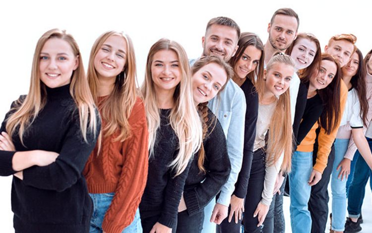 Junge Leute der Generation Z stehen lachend in einer Reihe